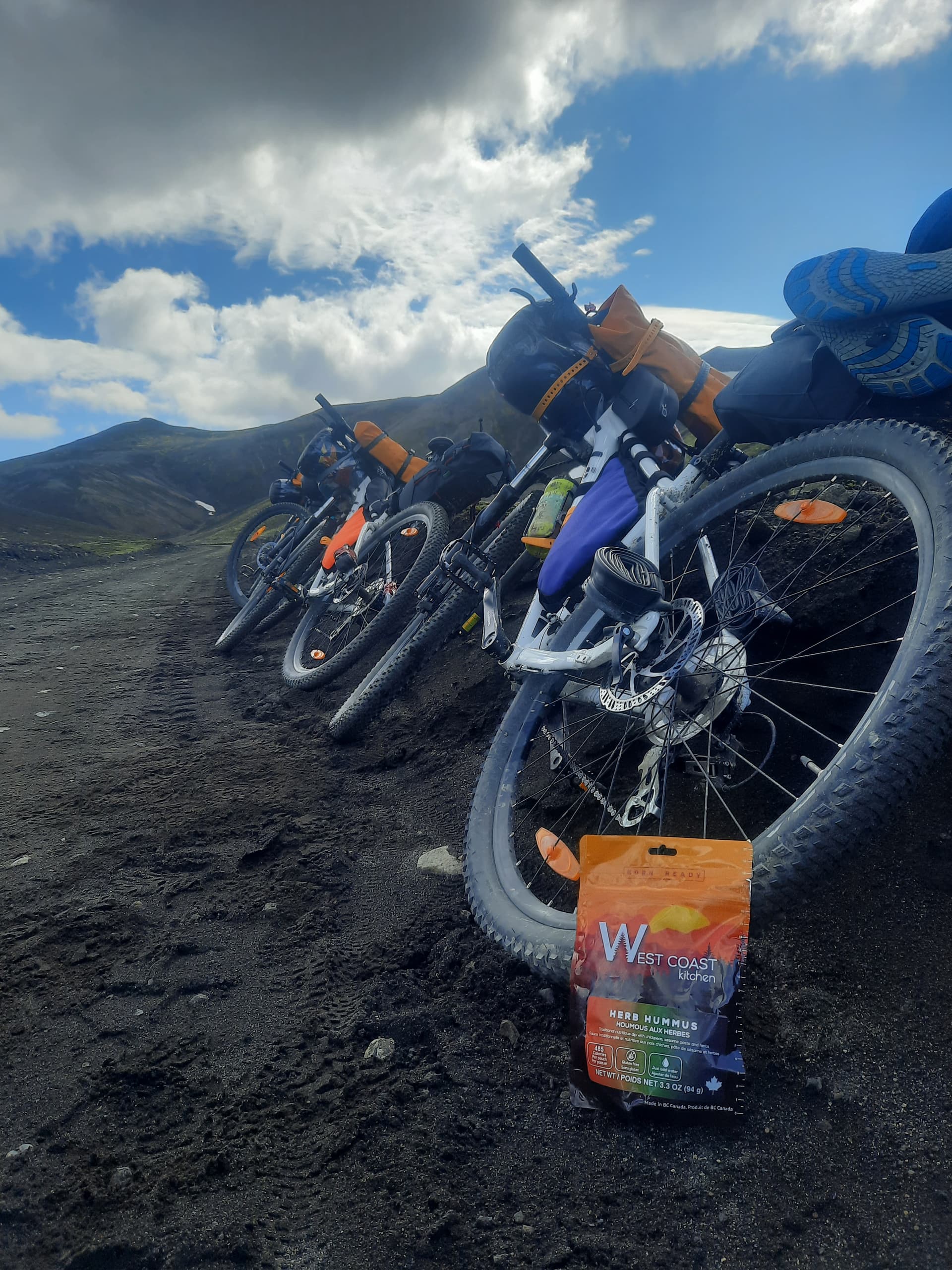 Loaded bikepacking bikes resting on black volcanic ground with WCK pouch in Iceland