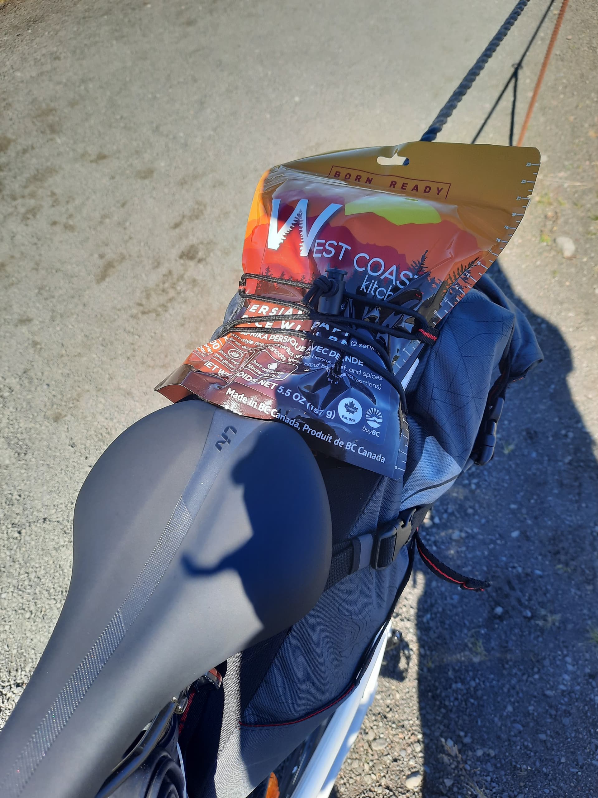 WCK meal pouch strapped to a bikepacking saddle bag on the roadside